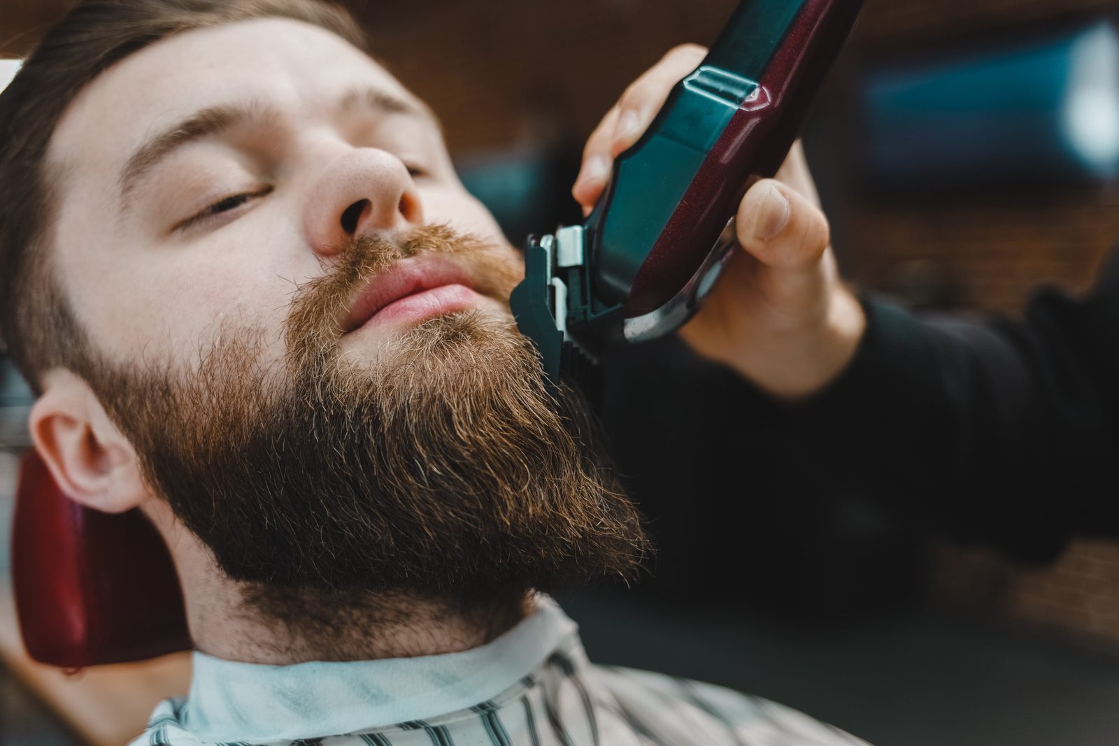 Barber master cuts a beard to a client close-up high-wycombe
